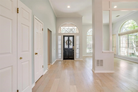 A hallway with a black piano in the middle.