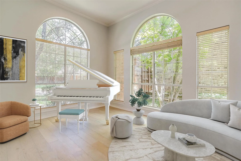A living room with a grand piano and a couch.