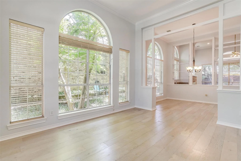 A spacious room with wooden floors and large windows.