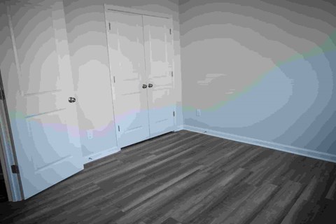 A room with a wooden floor and a wall with a map on it.