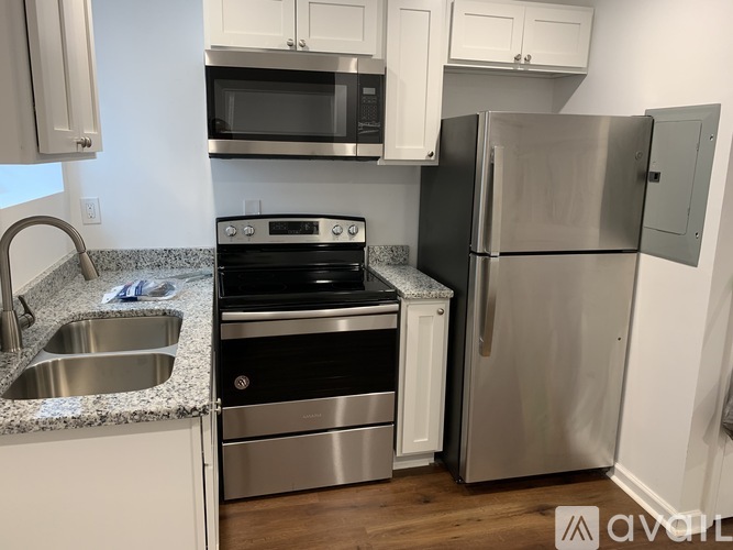 A kitchen with a stainless steel refrigerator, microwave, oven, and sink.