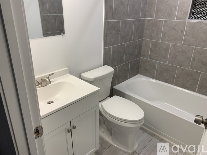 A bathroom with a toilet, sink, and bathtub.