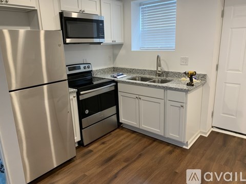 A kitchen with a stainless steel refrigerator and a black stove top oven.