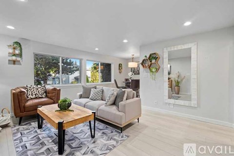 A living room with a brown leather chair and a grey sofa with a wooden coffee table in the middle.