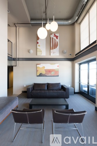 A living room with a grey couch and two chairs.