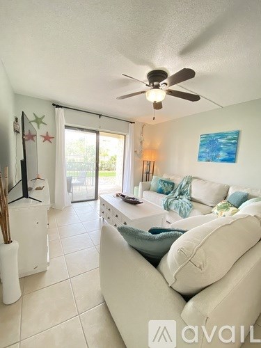 A living room with a white couch and a ceiling fan.