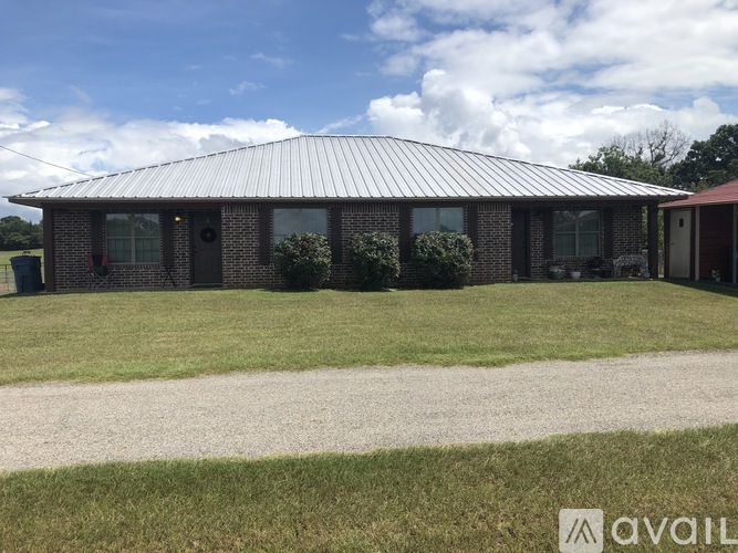 A house with a metal roof and a driveway in front.