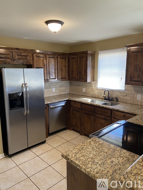 A kitchen with granite countertops and stainless steel appliances.