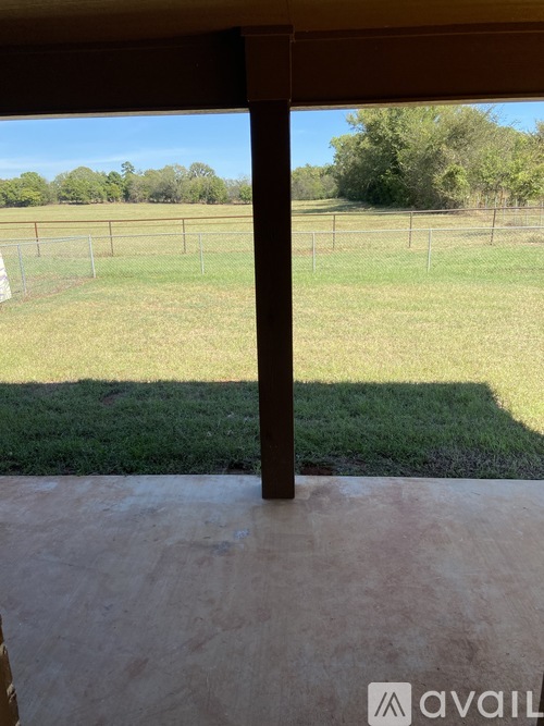 A view from a doorway looking out to a grassy field.