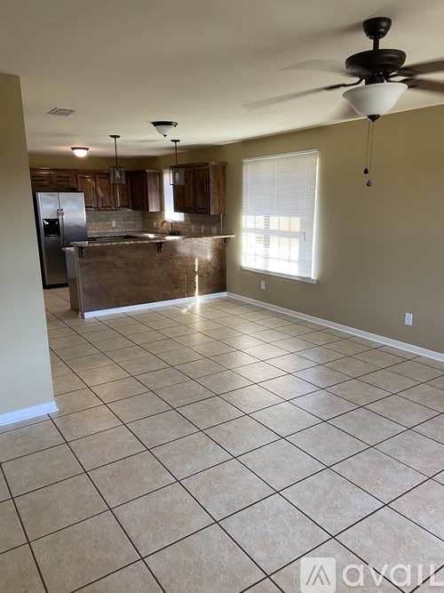 A kitchen with tile flooring and a ceiling fan.