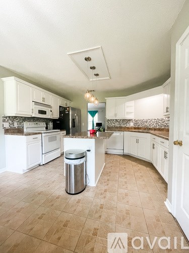 A kitchen with white cabinets and a tiled floor.