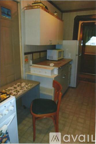 A small kitchen with a stove and a chair.