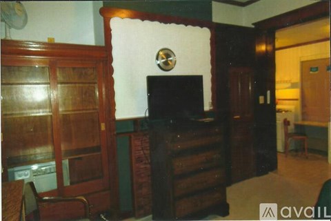 A living room with a television and wood paneling.