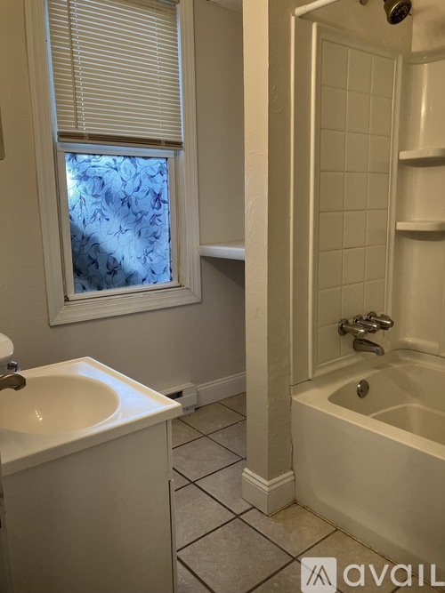 A bathroom with a white sink and a white bathtub.
