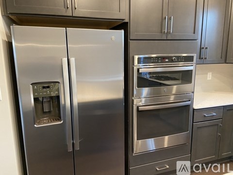 A stainless steel refrigerator and oven in a kitchen.