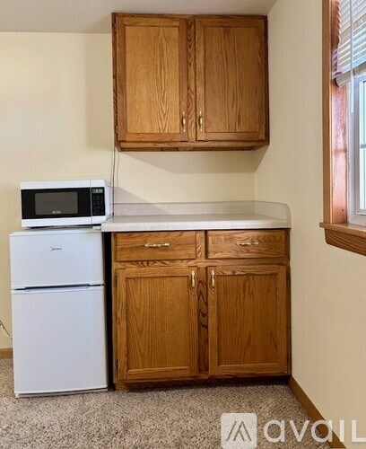 A kitchen with wooden cabinets and a white fridge.