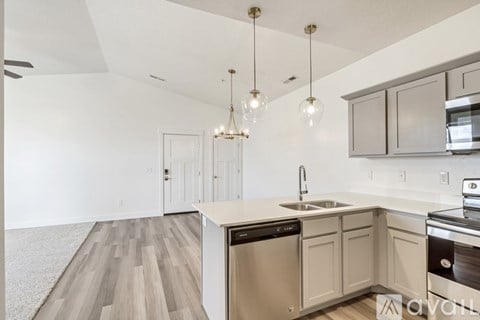 A kitchen with a sink, dishwasher, and stove top oven.