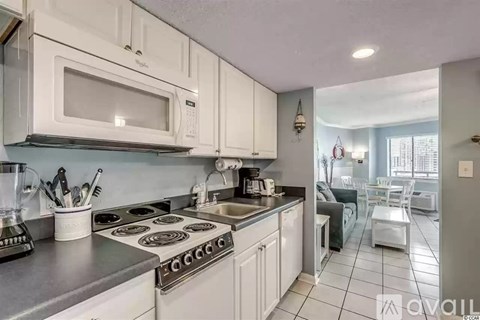 A kitchen with white cabinets and a stove top oven.