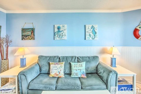 A living room with a couch and ocean-themed decorations.