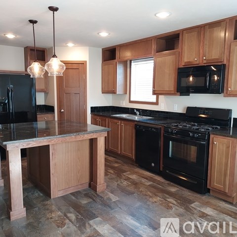 A kitchen with wooden cabinets and black appliances.