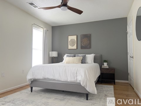 A bedroom with a bed, nightstand, and two wall art pieces.