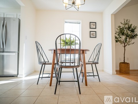 A dining room with a table and chairs.