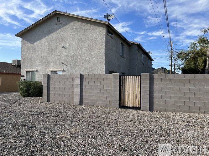 A grey house with a brown fence in front of it.