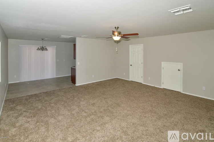 A spacious room with a ceiling fan and carpeted floor.