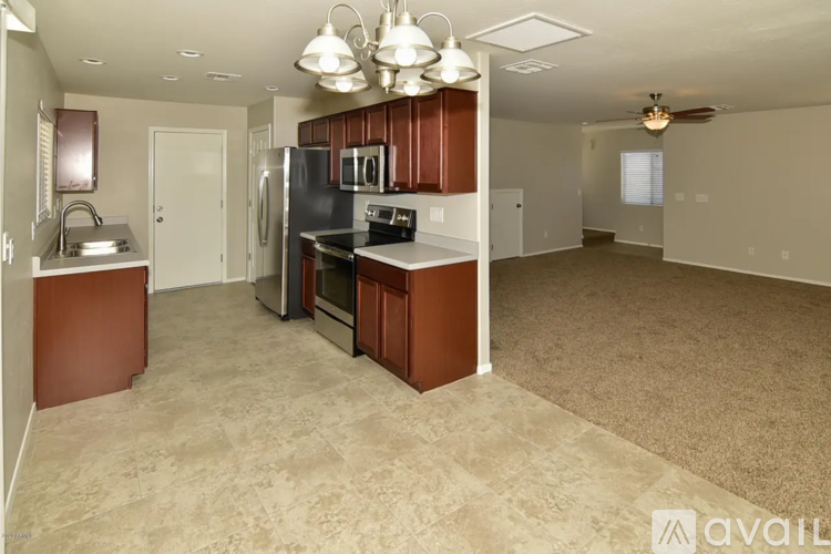 A kitchen with brown cabinets and a black refrigerator.