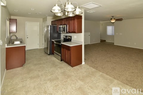 A kitchen with brown cabinets and a black refrigerator.