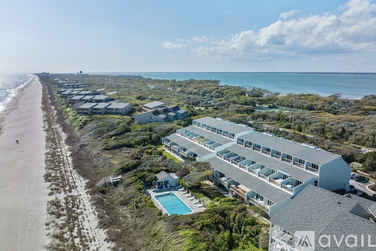 A beachfront property with a swimming pool and a row of houses.