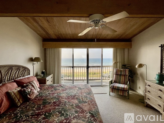 A bedroom with a large bed and a view of the ocean.