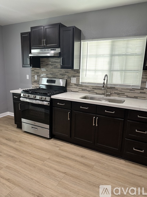 A kitchen with a stove, oven, and sink.