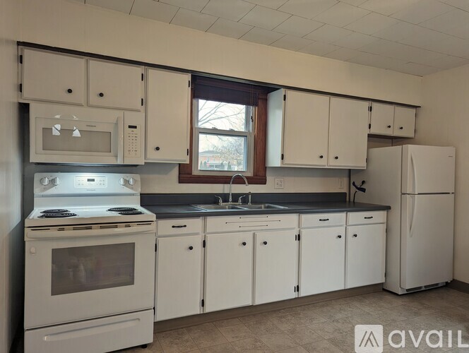 A kitchen with white appliances and cabinets.