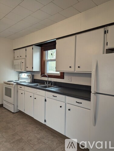 A kitchen with white cabinets and a black countertop.