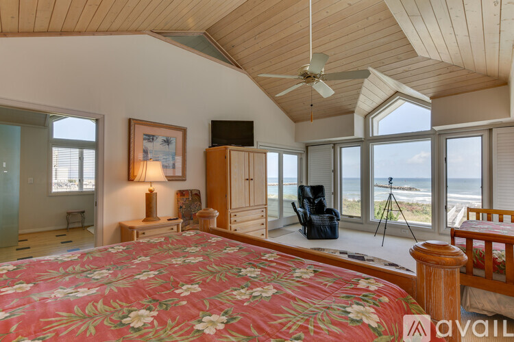 A bedroom with a large bed and a view of the ocean.