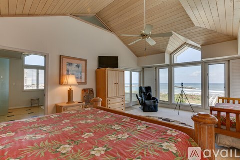 A bedroom with a large bed and a view of the ocean.