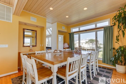 A dining room with a wooden table and chairs.