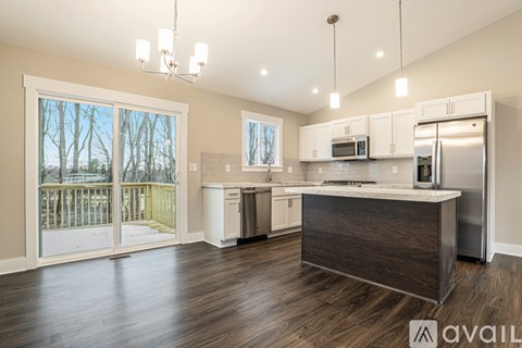 A kitchen with a refrigerator, microwave, and oven is available for rent.