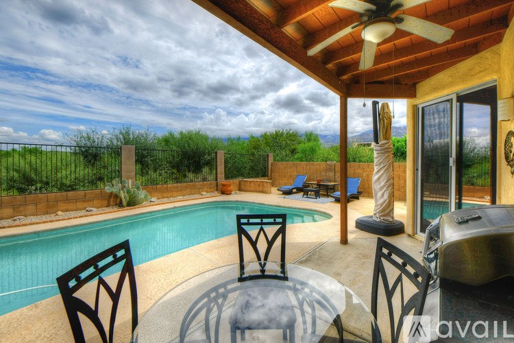 A poolside patio with a table and chairs.