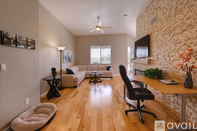 A living room with a brick wall and a ceiling fan.