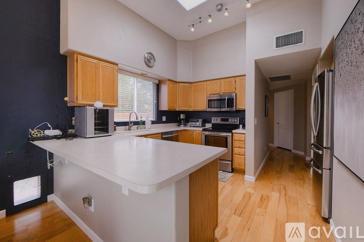 A kitchen with a white countertop and wooden cabinets.