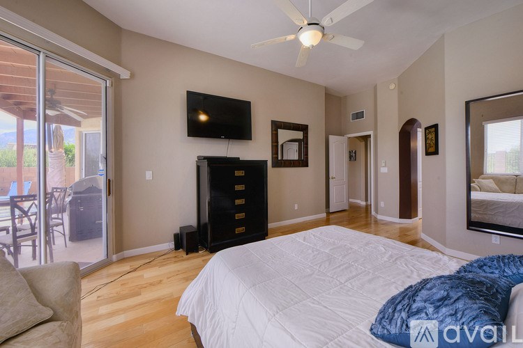 A bedroom with a large bed and a flat screen TV mounted on the wall.