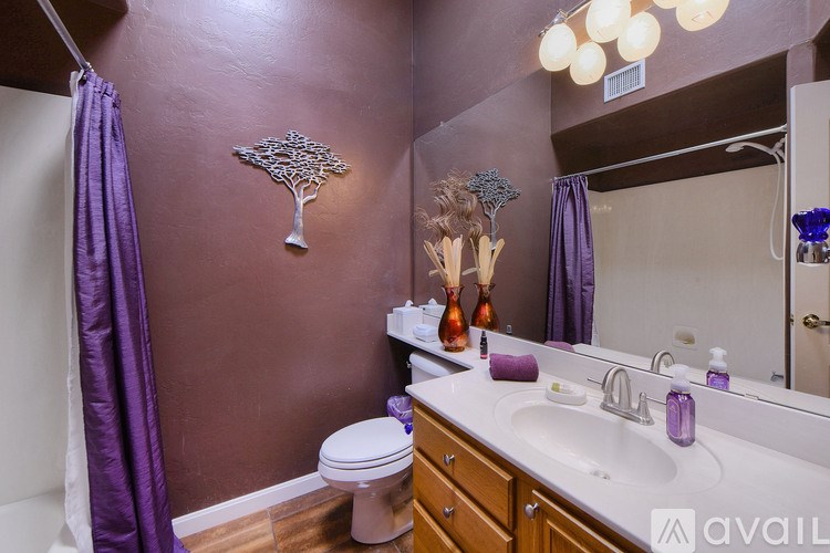 A bathroom with purple curtains and a white toilet.