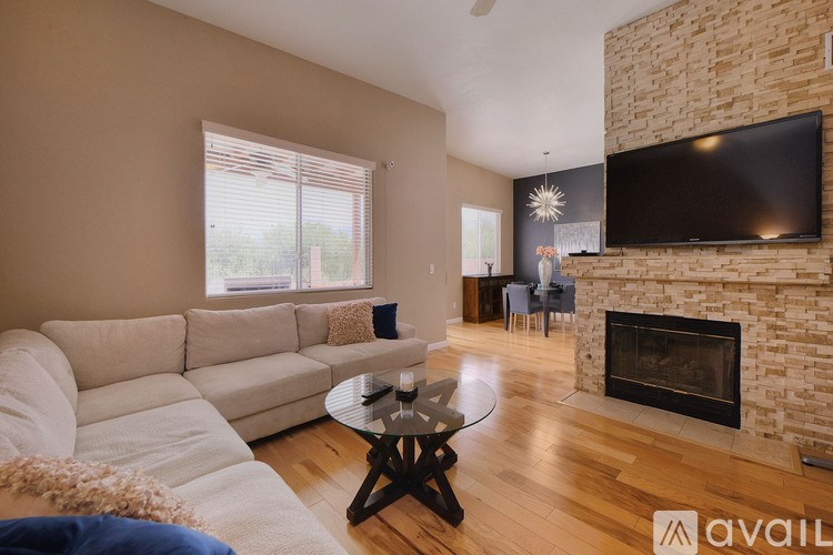 A living room with a white couch and a fireplace.