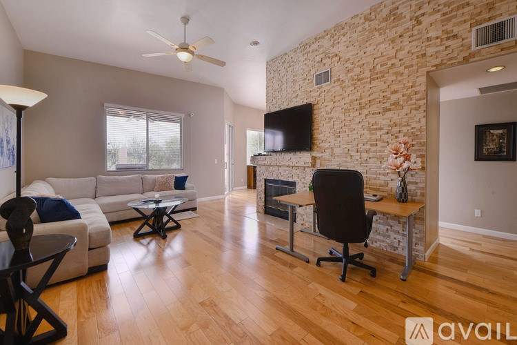 A living room with a white couch and a black chair.