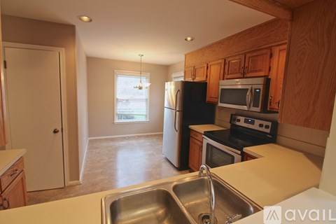 A kitchen with wooden cabinets and a stainless steel sink.