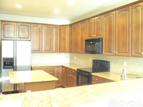 A kitchen with wooden cabinets and granite countertops.