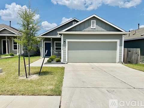 A house with a garage and a driveway in front.