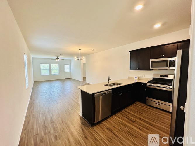 A kitchen with dark wood cabinets and stainless steel appliances.